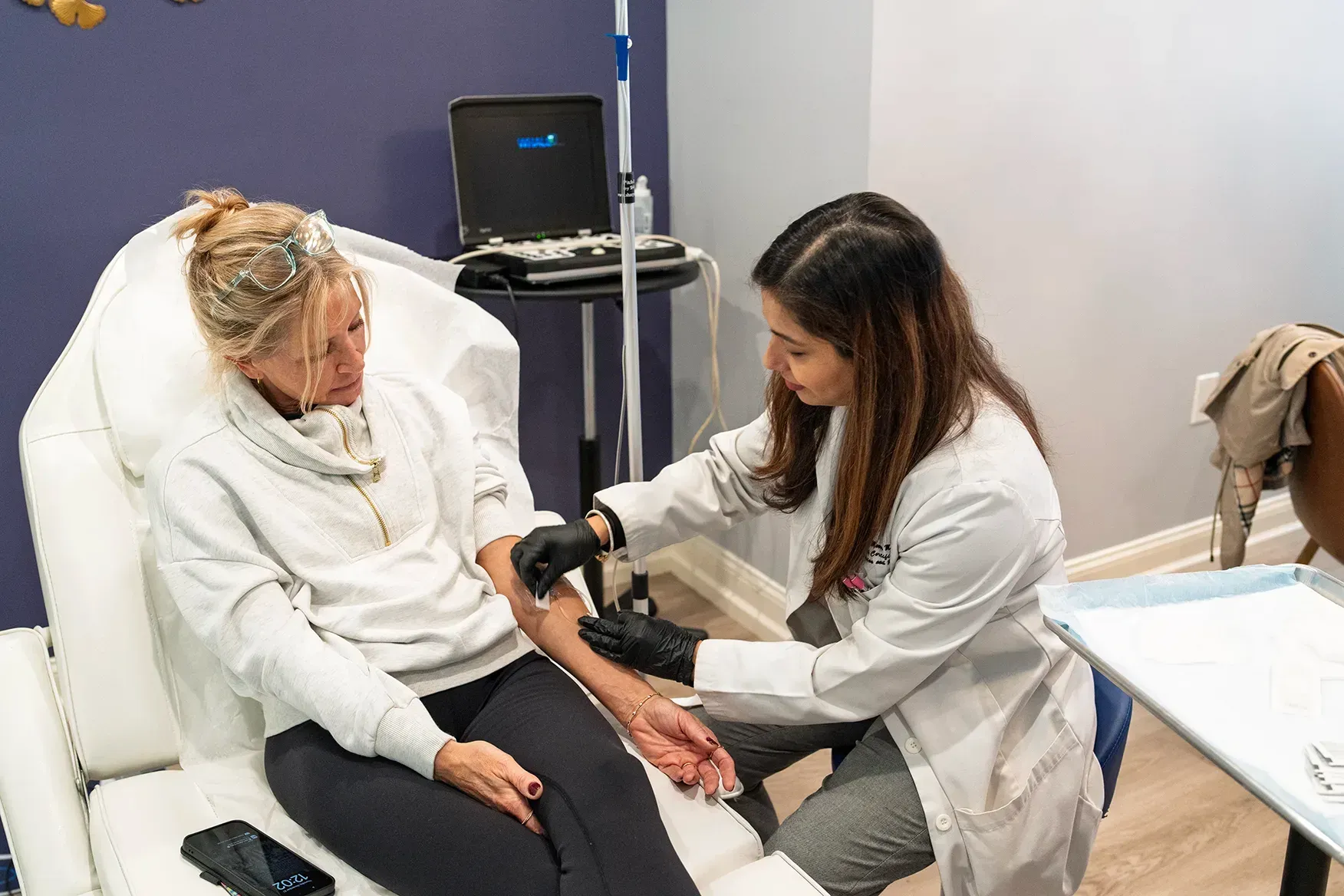 A clinician performing an ultrasound-guided treatment on a patient