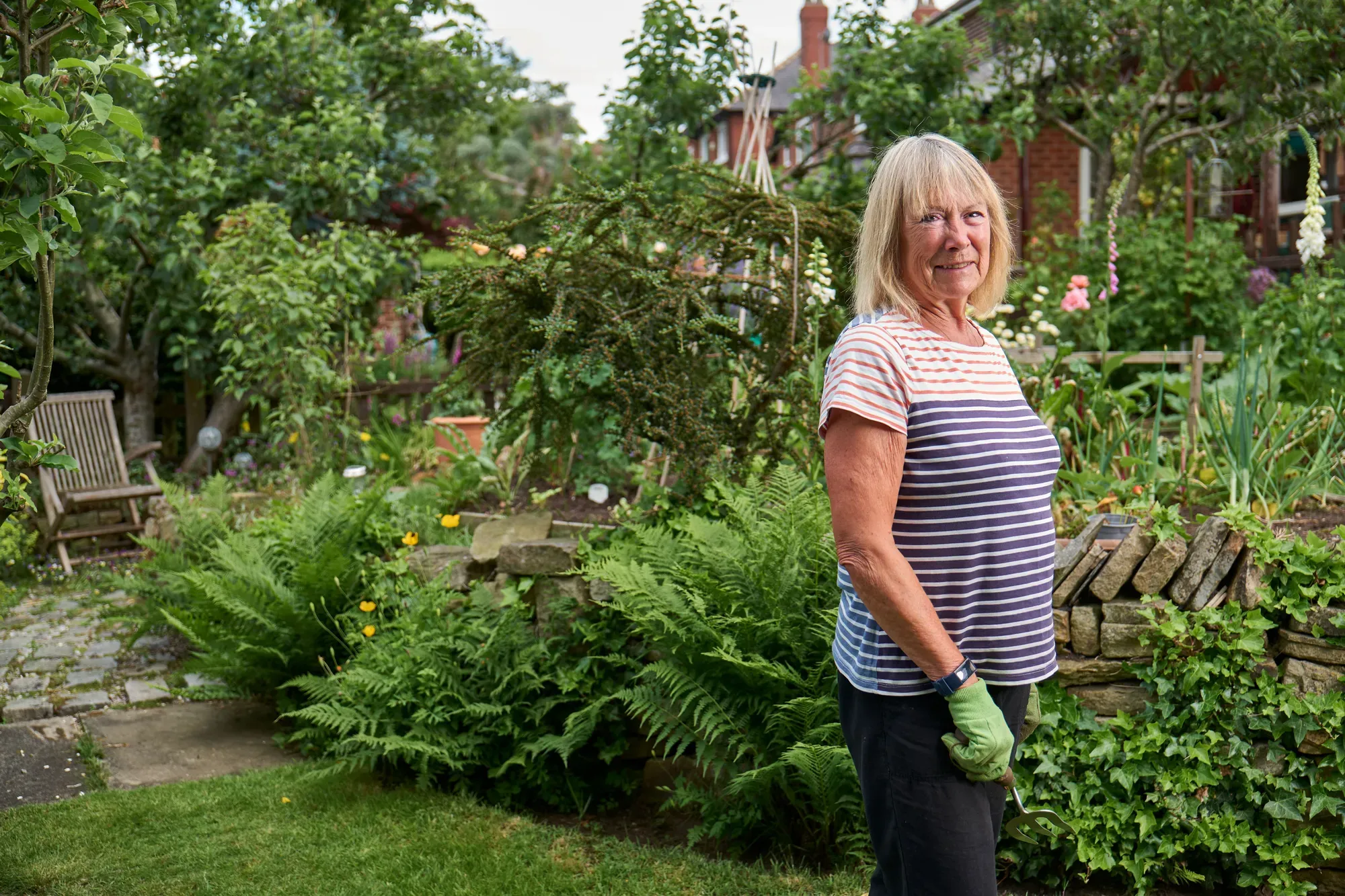 A woman standing among the beds of her garden